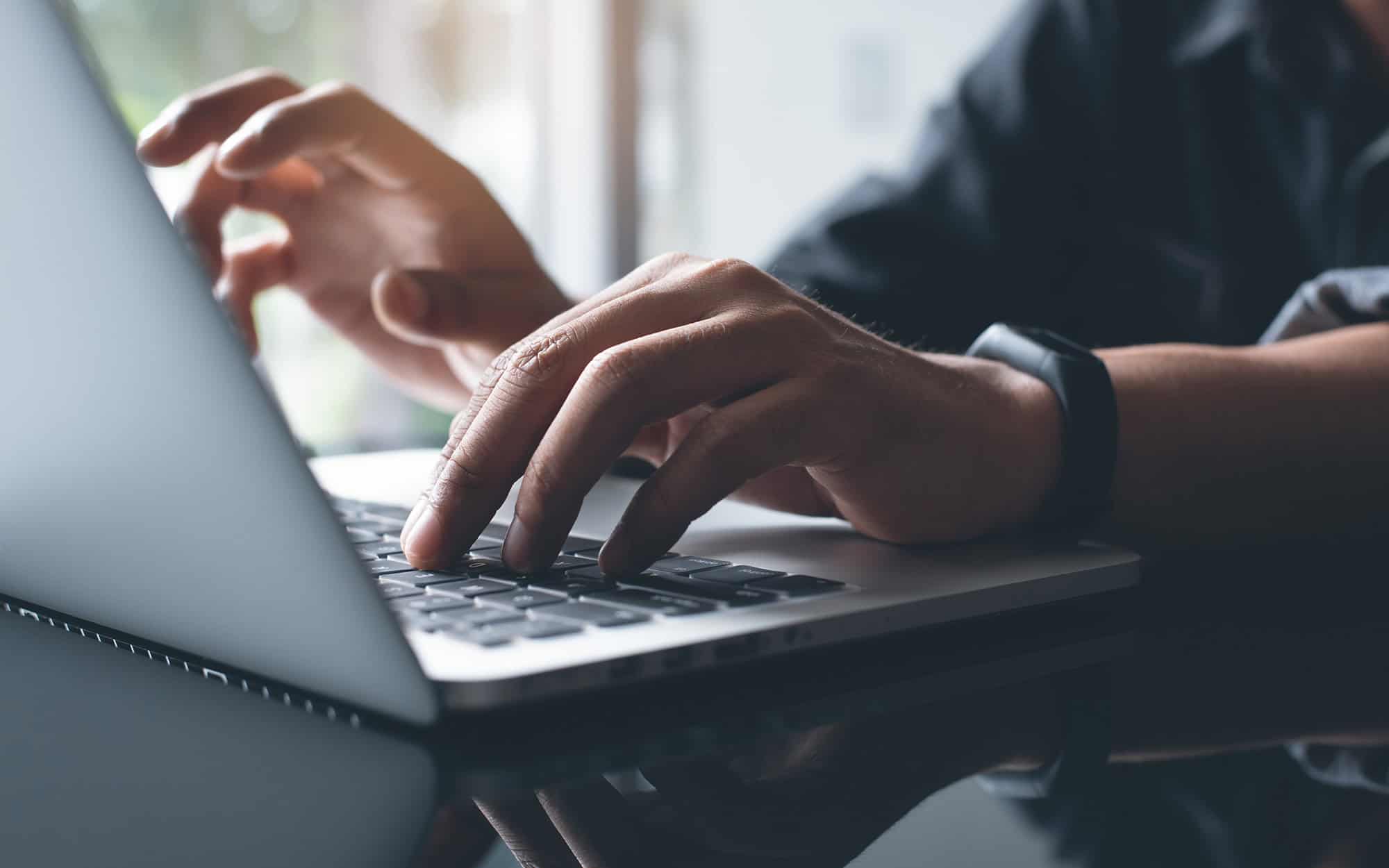 Close Up of Hands Typing on Laptop Computer