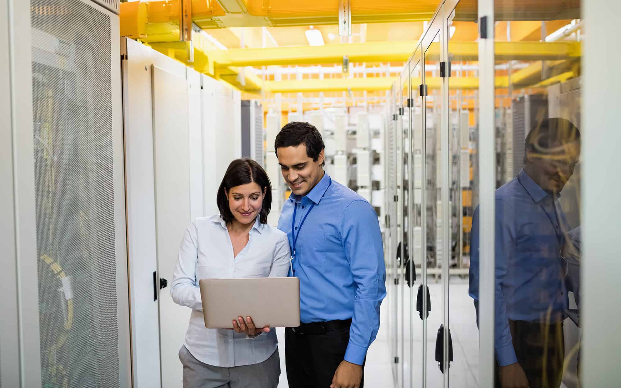 Analysts in Server Room Looking at Laptop