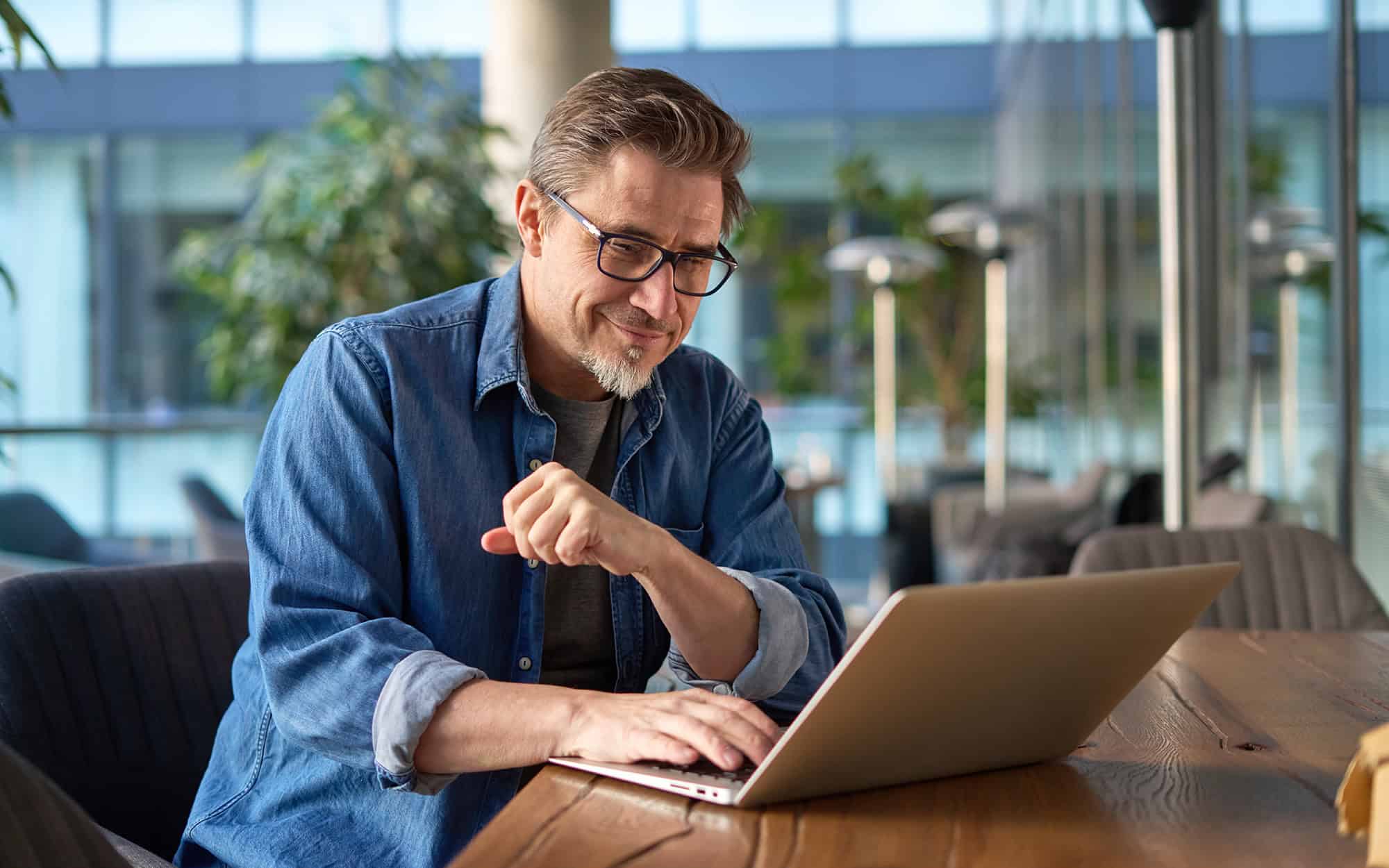 Businessman Using Laptop in Office Common Area