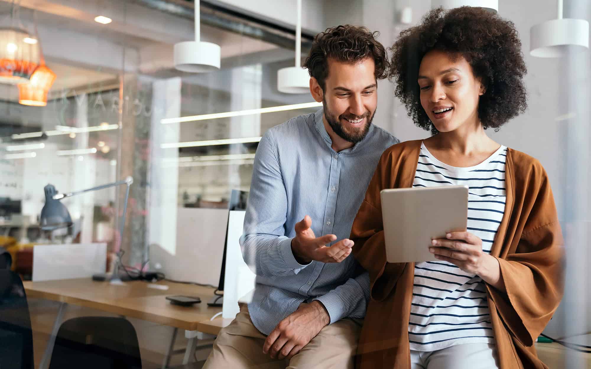 Coworkers Looking at Tablet in Office