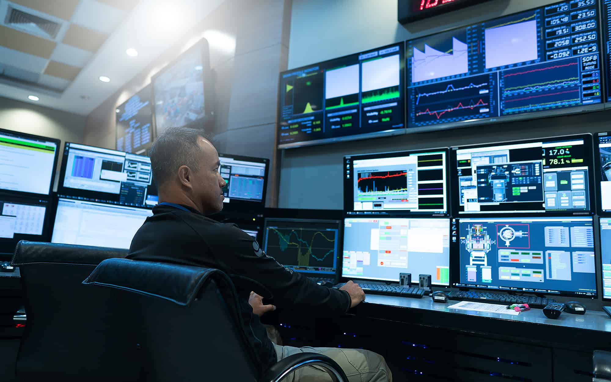 Man in Security Operations Center Looking at Monitors