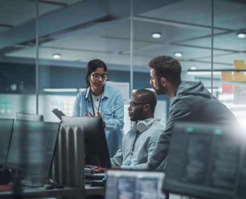 Side view of three cybersecurity professionals having a meeting